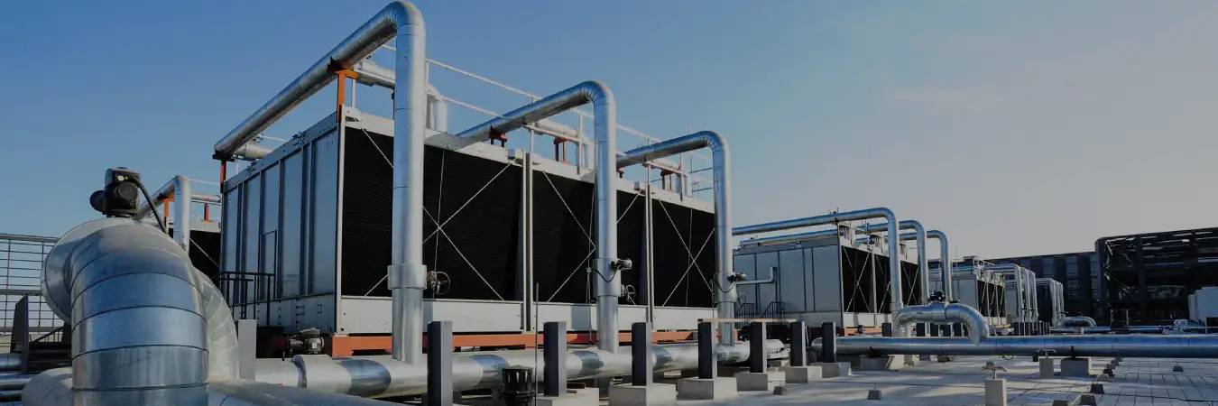 Row of induced draft cooling tower cells on an industrial rooftop